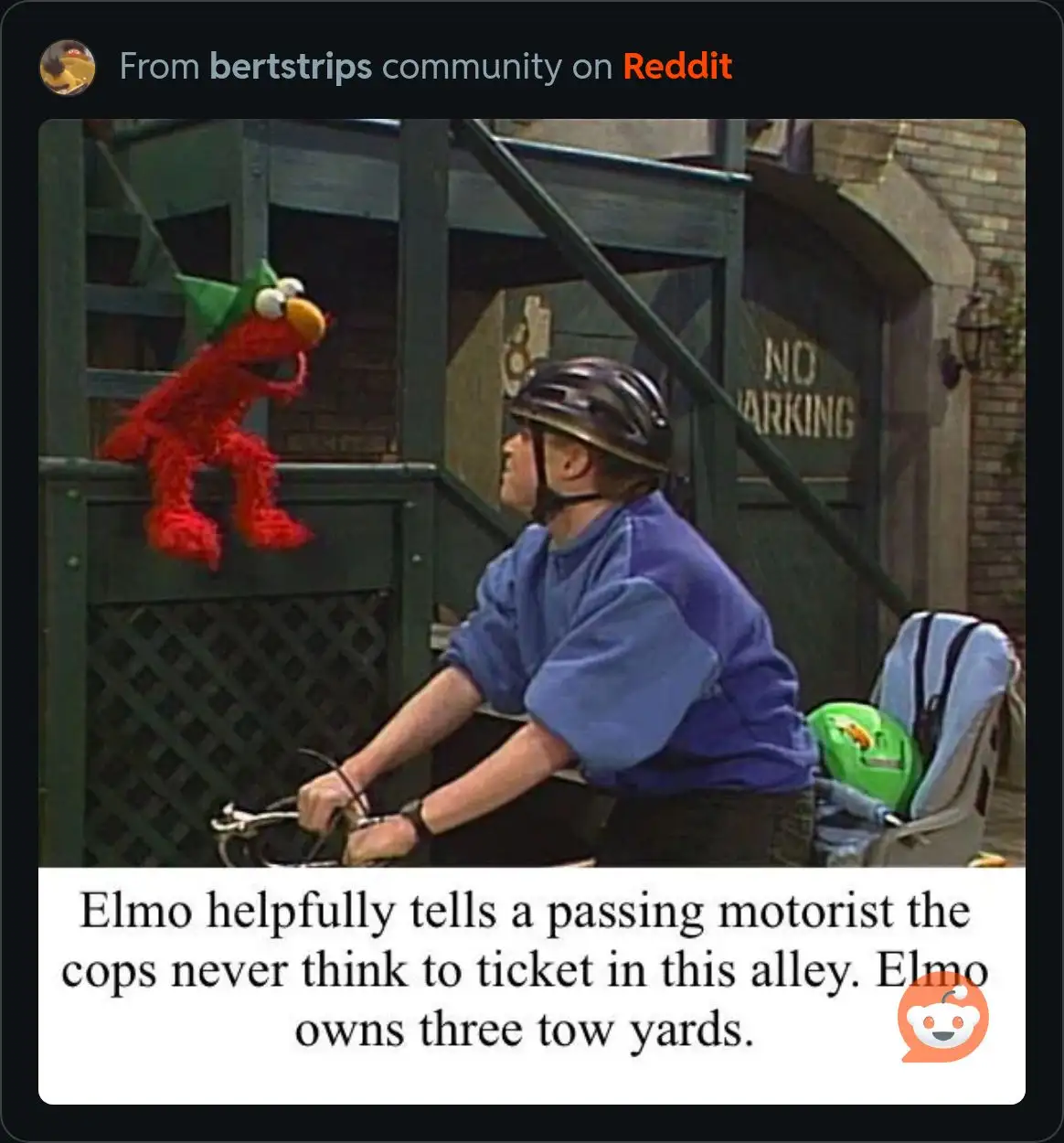 A still from a Sesame Street scene shows Elmo, a red furry puppet wearing a green hat, perched on a green metal fence. Below…