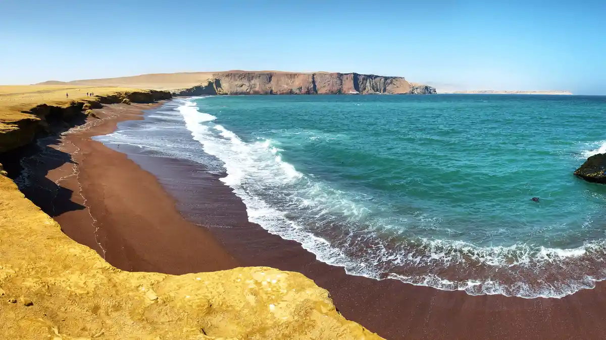 In Peru's Paracas National Reserve, explore the contrasting beauty of Playa Roja, where deep red sands meet the Pacific…