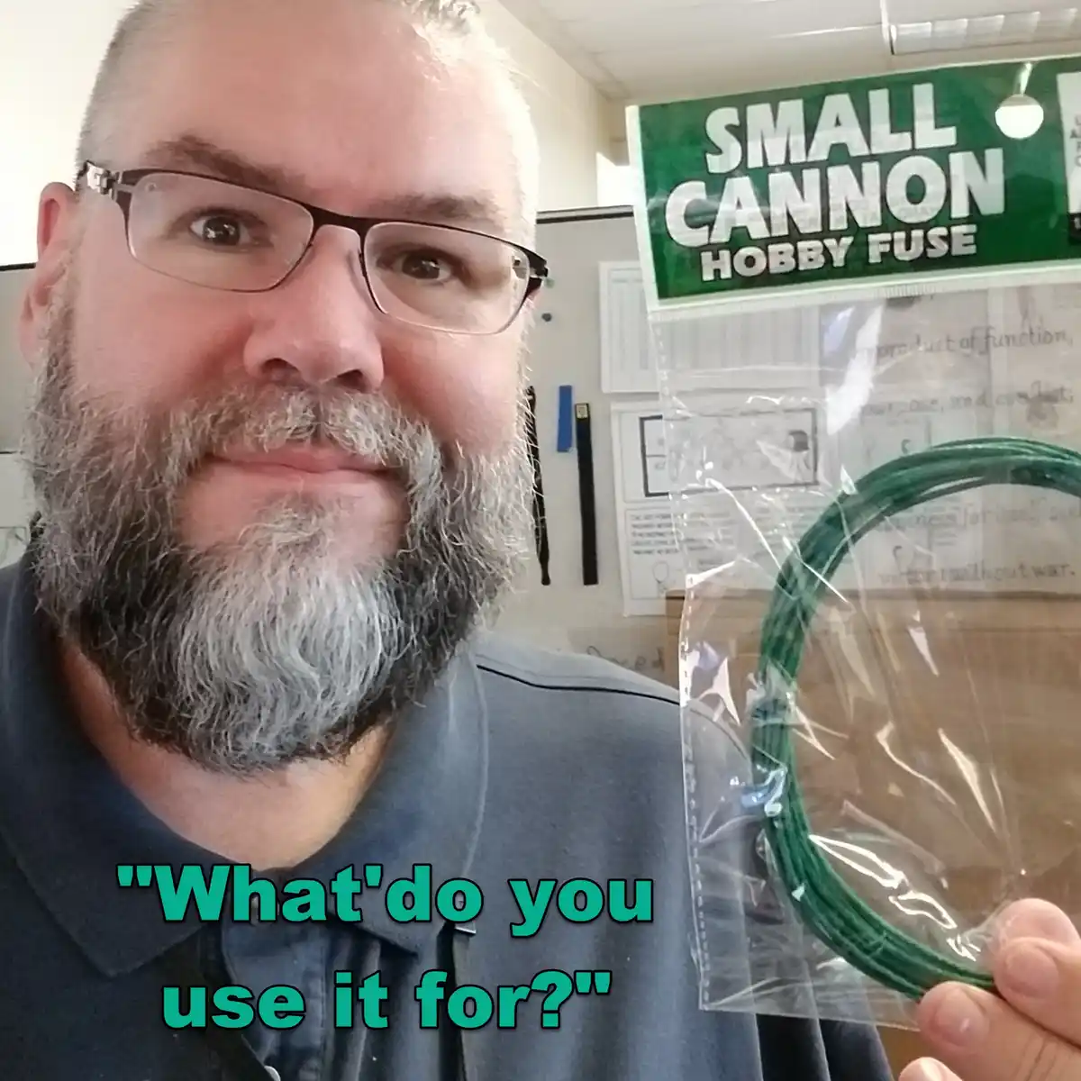 A man with glasses and a gray beard holds up a package labeled 'SMALL CANNON HOBBY FUSE' containing a coiled green fuse. He…