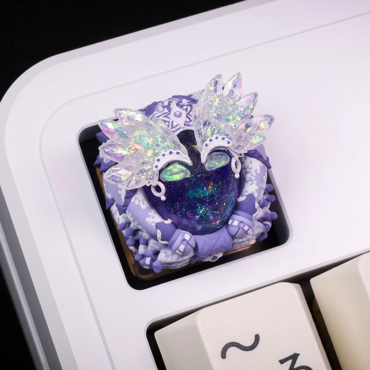 A highly detailed, custom keycap on a white mechanical keyboard features a fantasy-themed design with a purple and white…