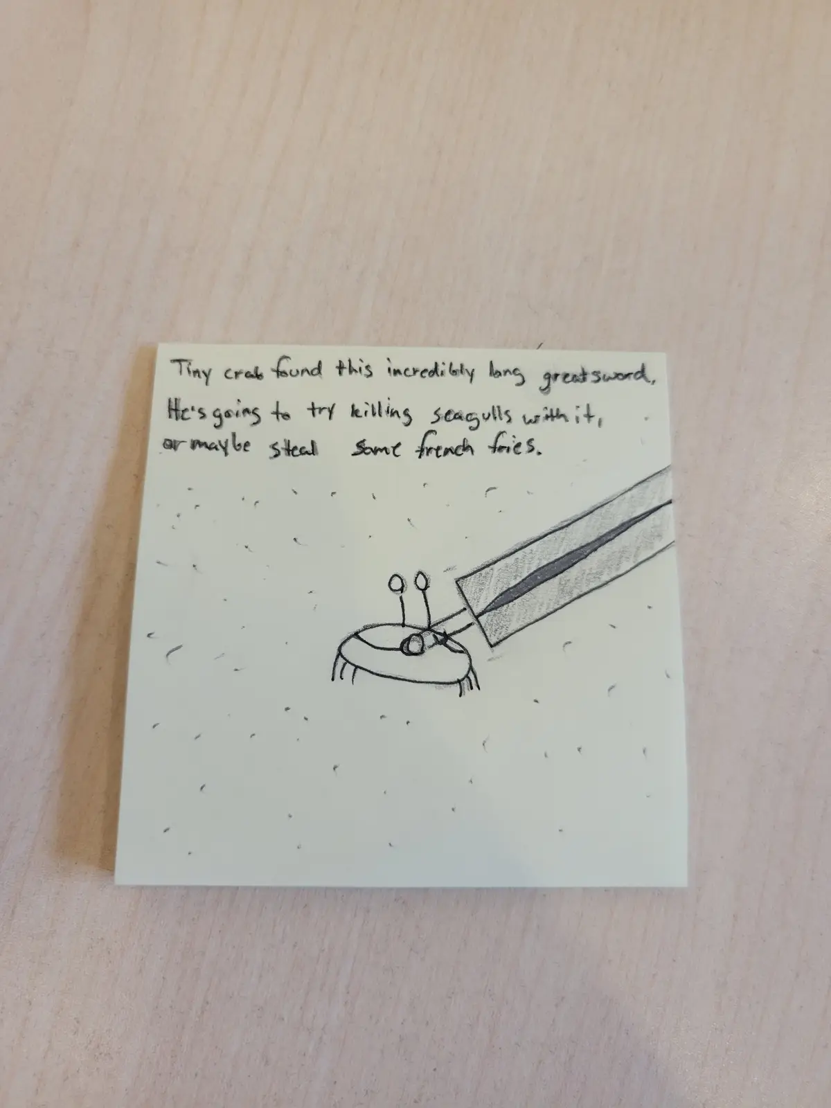 A hand-drawn sketch on a sticky note shows a tiny crab holding an absurdly oversized greatsword. The crab is drawn simply…