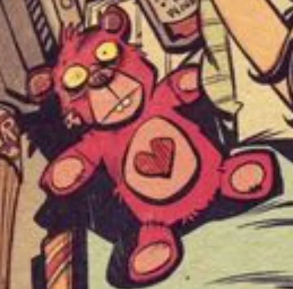 A cartoonish, red, furry teddy bear with yellow eyes and a heart emblem on its chest is shown in a comic book panel, looking…