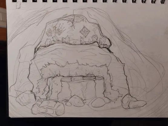 A pencil sketch on spiral-bound paper depicts a cozy, rustic stone fireplace with a large, patterned blanket draped over the…