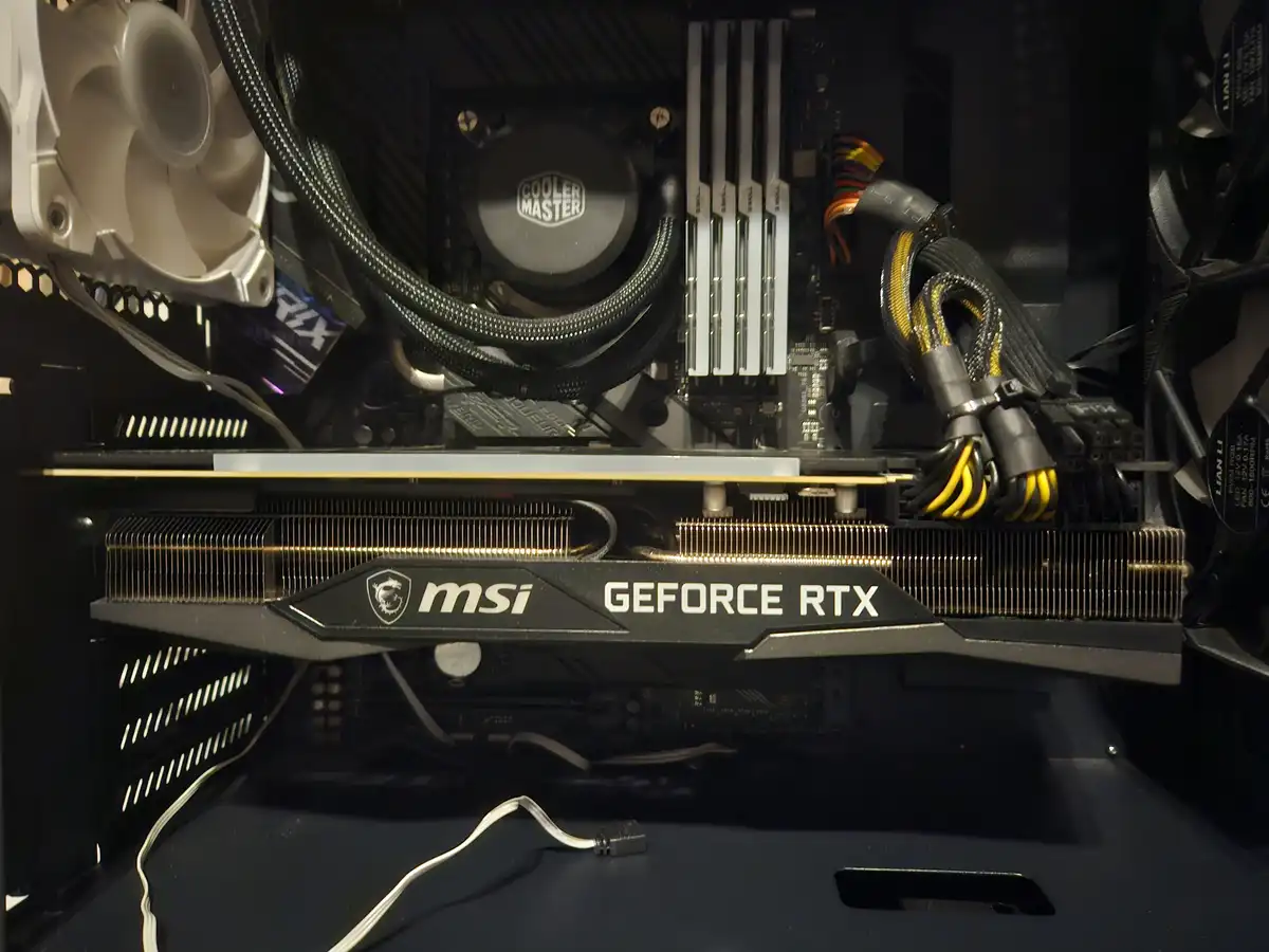 A close-up photo of the inside of a computer case showing an MSI GeForce RTX graphics card installed in a motherboard. Above…