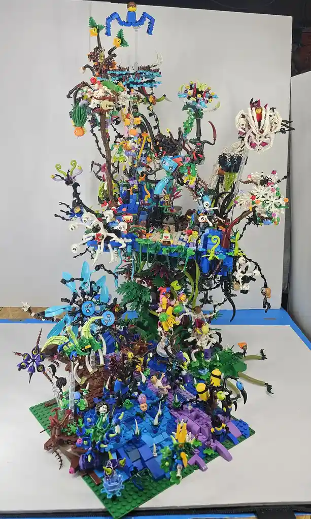 A towering, chaotic, and densely packed LEGO sculpture resembling a jungle or treehouse, featuring numerous minifigures…