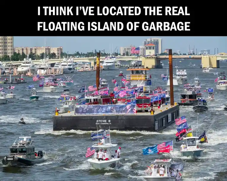 A crowded waterway filled with numerous boats, many decorated with American flags and 'TRUMP 2020' campaign banners…
