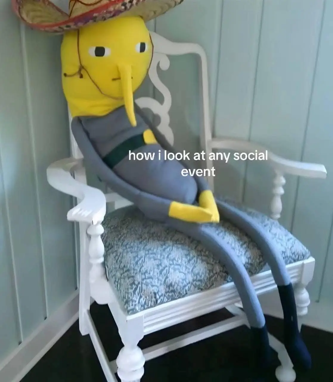 A plush toy of the character Prince Hans from Disney's Frozen, wearing a sombrero and lounging in a white rocking chair with…