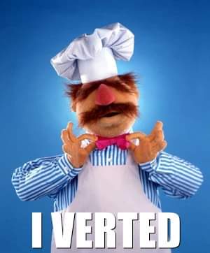 A Muppet character with a red nose, brown mustache, and chef's hat is adjusting a pink bowtie while wearing a striped shirt…