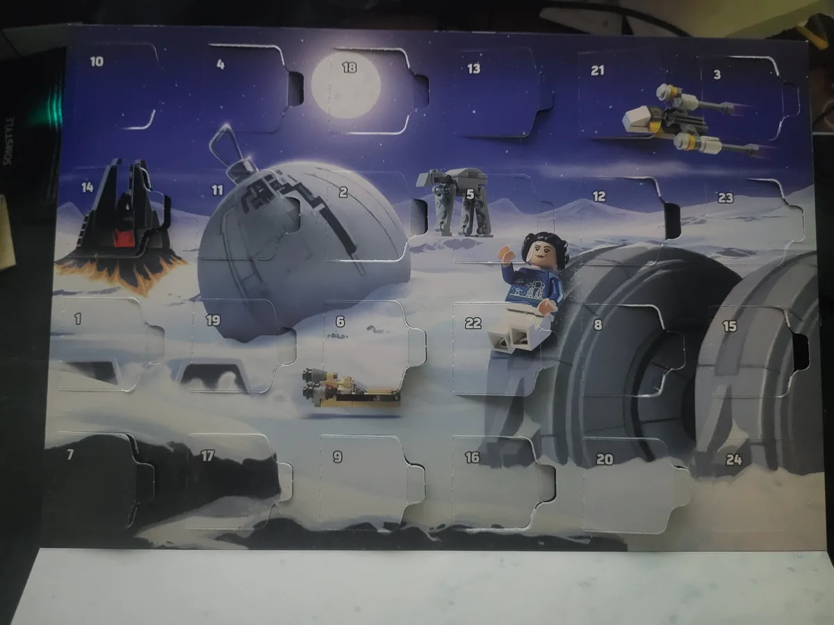 A LEGO Star Wars advent calendar with 24 numbered compartments, many of which are open to reveal Star Wars-themed miniatures…