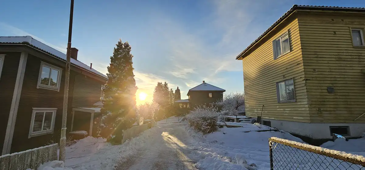 A snowy residential street at sunrise, with houses on both sides and snow-covered trees, overlaid with the text 'i'm not…