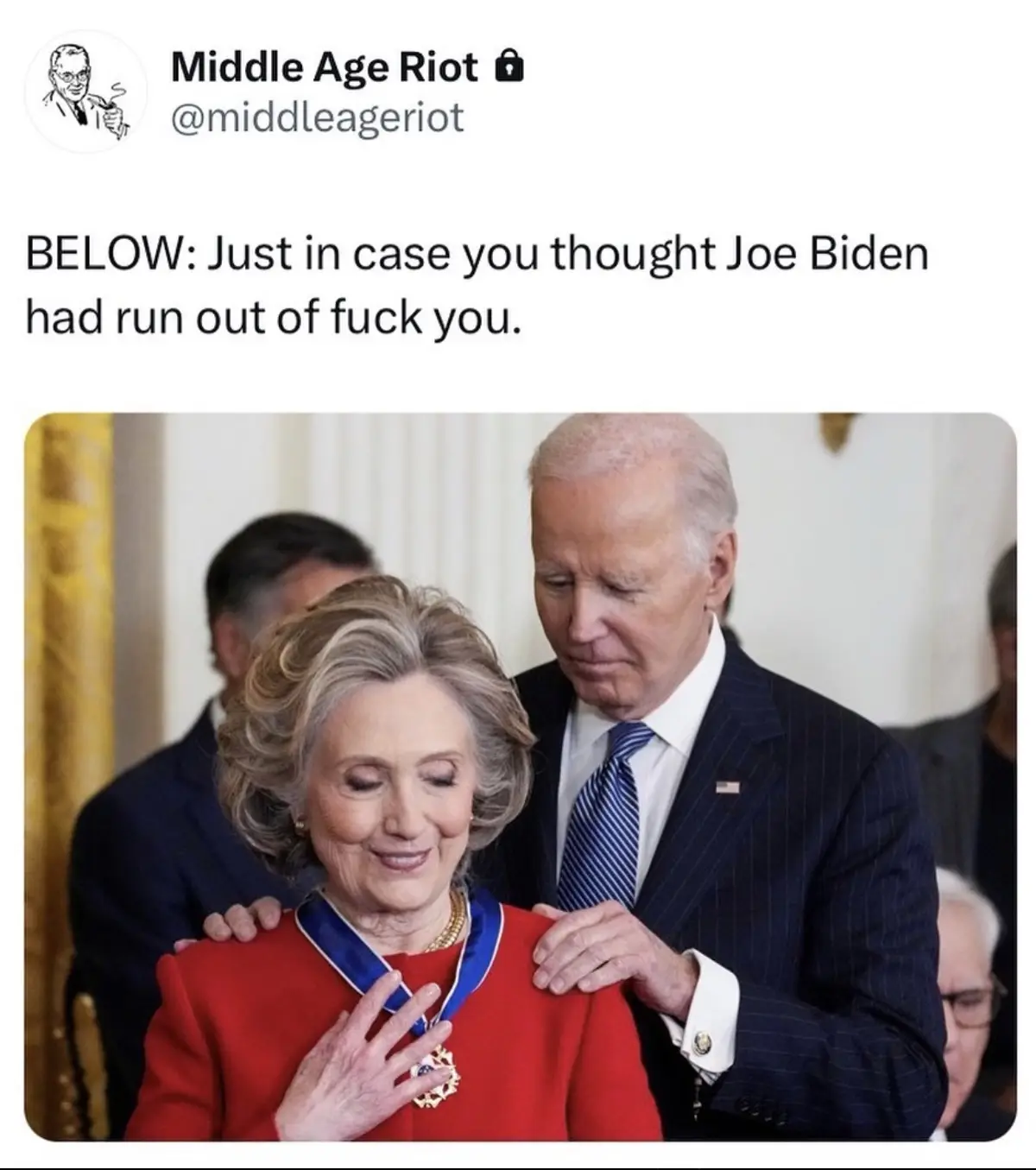 A photo shows Joe Biden placing a medal on Hillary Clinton's chest while she smiles. Biden is in a dark suit with a blue…