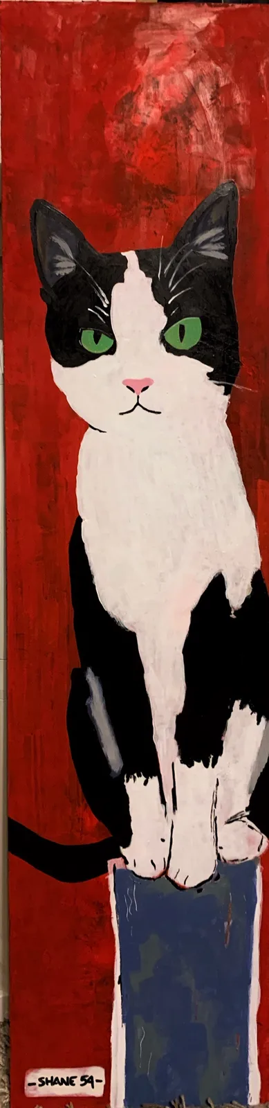 A stylized painting of a black and white cat with bright green eyes, sitting upright on a blue block against a textured red…