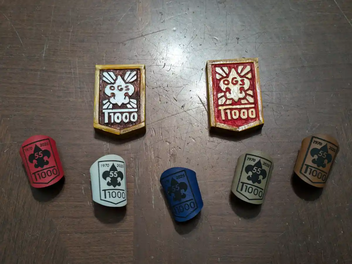 Six custom-made, hand-painted wooden tokens are arranged on a scratched wooden surface. Two larger rectangular tokens…