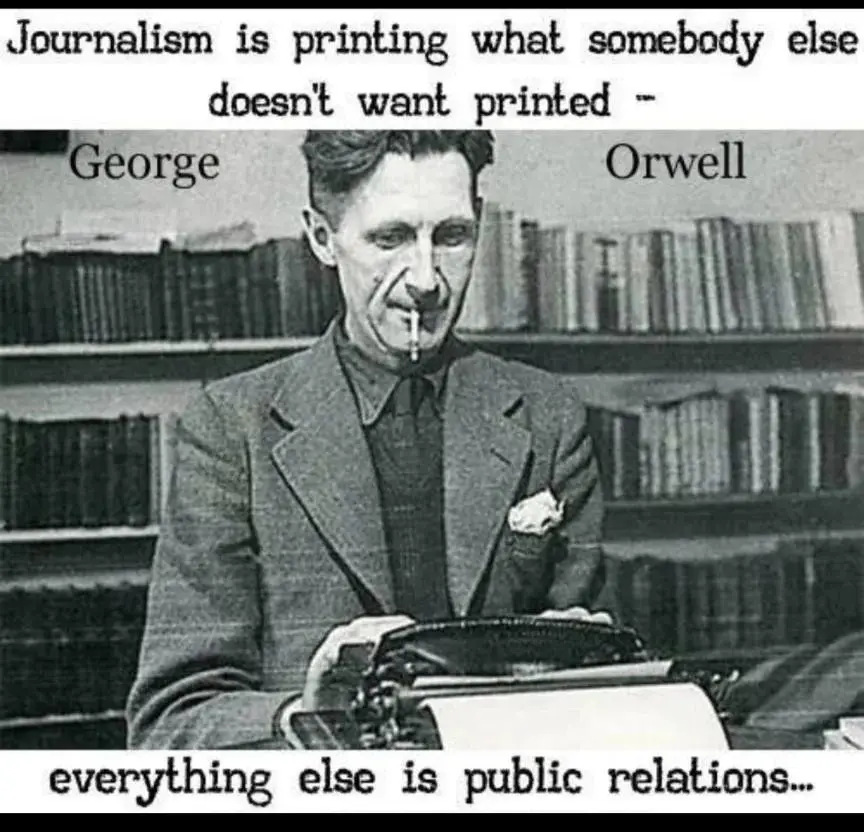 A black-and-white photo of George Orwell sitting at a typewriter with a cigarette in his mouth, surrounded by bookshelves…