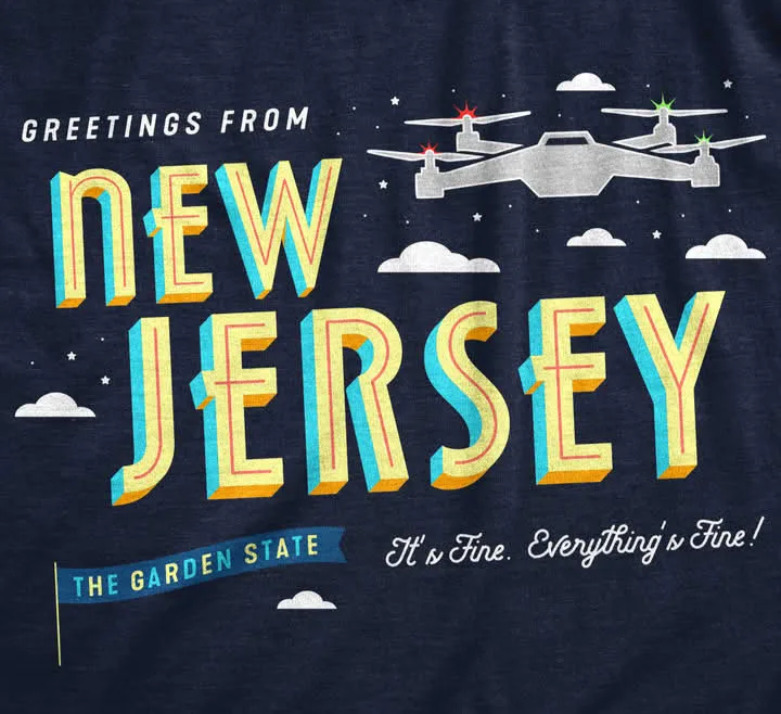 A graphic t-shirt design with a dark blue background, featuring large 3D-style text reading 'Greetings from New Jersey' and…