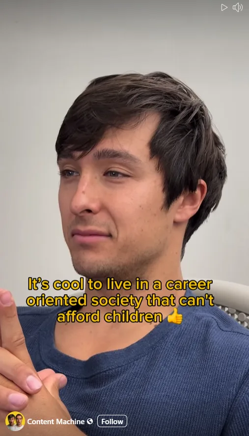 A man with dark hair and a blue shirt looks at the camera with a slight smirk while holding his hands together. Yellow text…