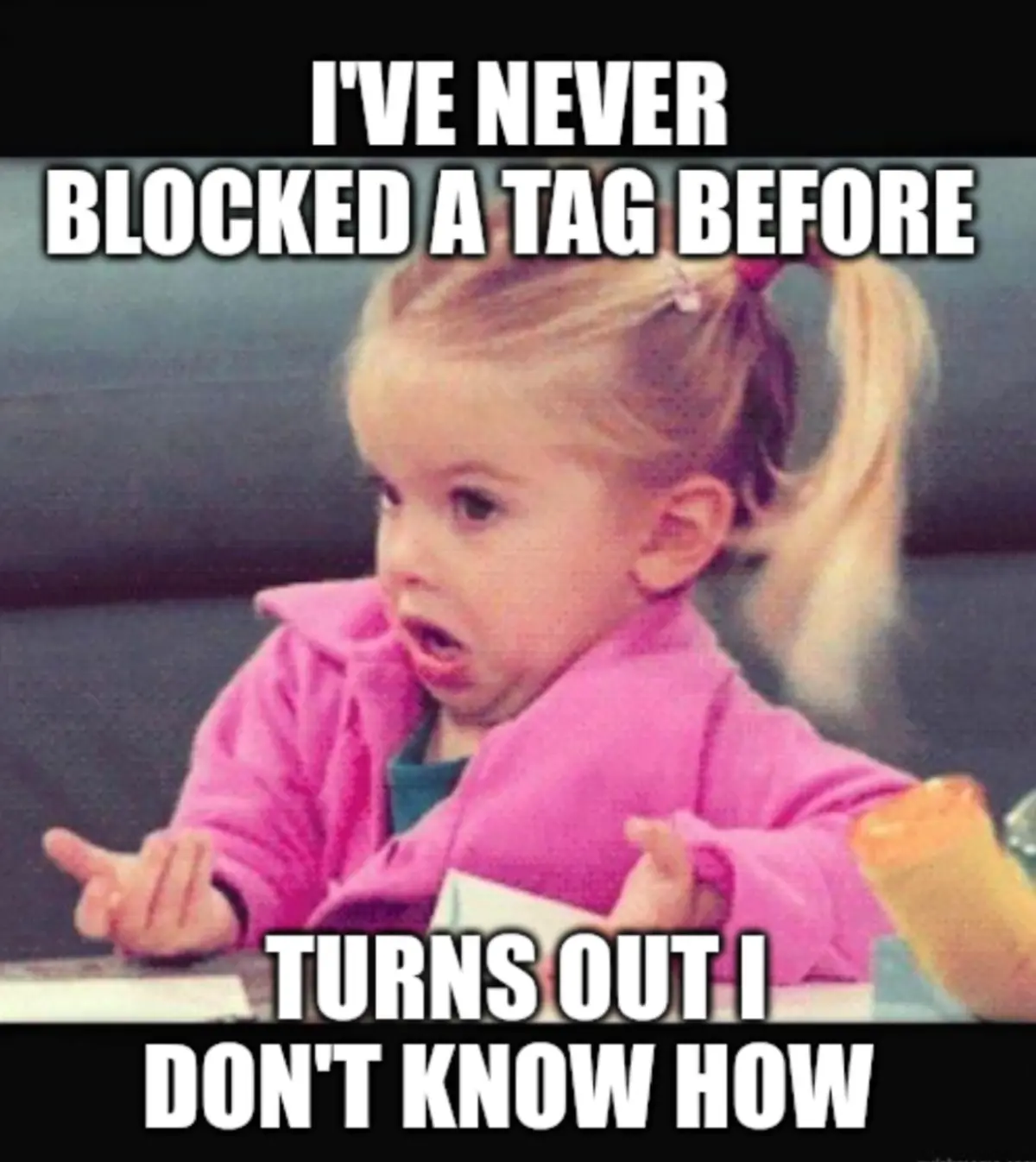 A young girl with blonde hair in a ponytail, wearing a pink jacket, looks confused and shrugs with both hands open. The…