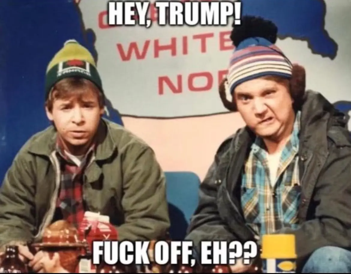 Two men in winter hats sit in front of a map backdrop with partial red text reading 'WHITE NO'. The man on the left looks…