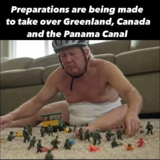 A shirtless older man wearing a bicycle helmet and a diaper sits on a carpeted floor, intensely focused on playing with toy…