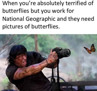 A man with dark hair and a black shirt, visibly terrified, is holding a large camera with a zoom lens, aiming it forward. A…