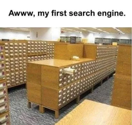 An image of a large room filled with wooden card catalogues, each with many small drawers, arranged in long rows. The…