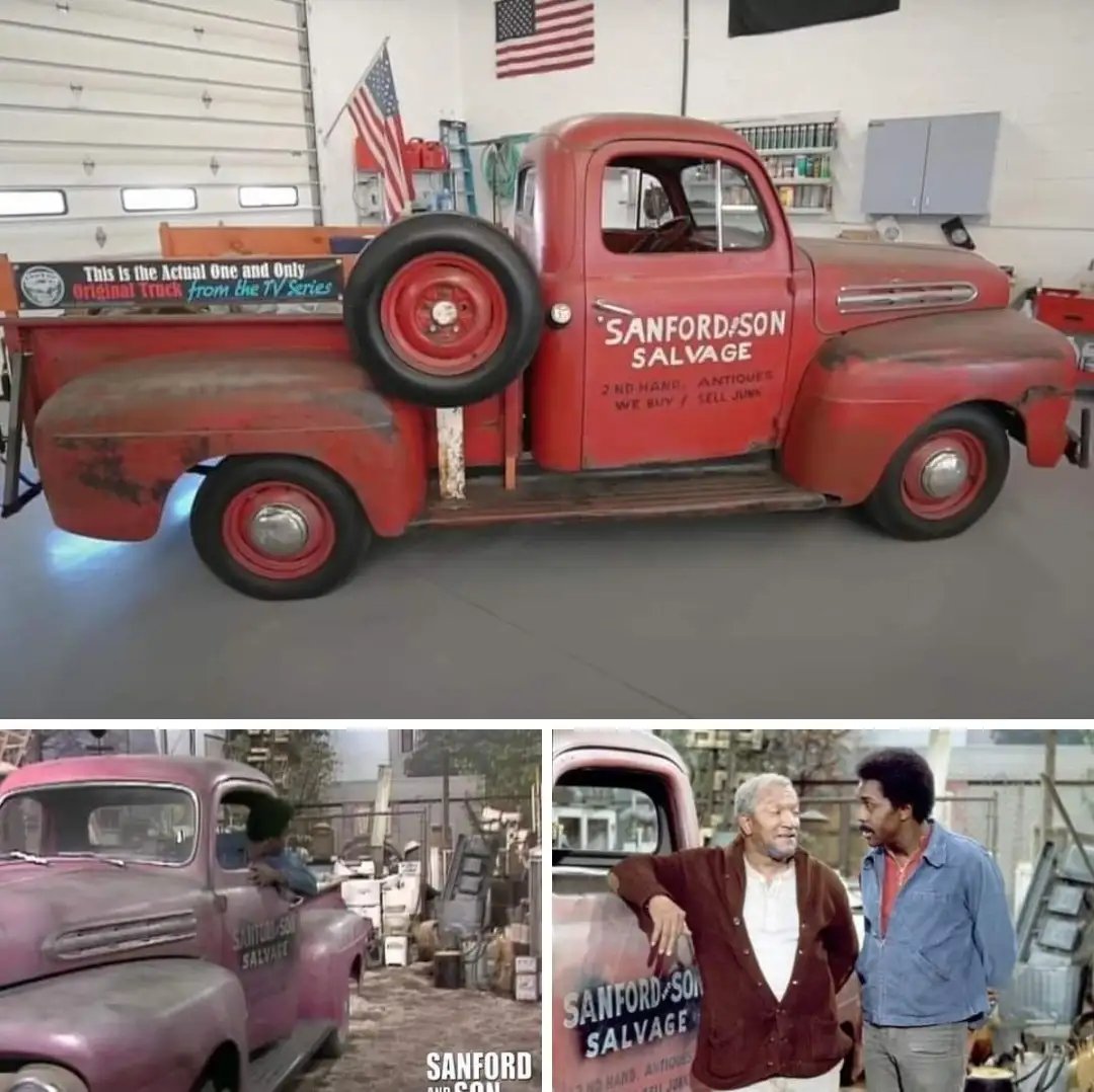 A red vintage Ford pickup truck with 'SANFORD & SON SALVAGE' painted on its side is displayed in a clean garage, with a…