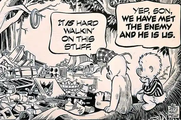 A black-and-white comic panel from 1971 by Walt Kelly shows two characters, an adult and a child, sitting in a junkyard…