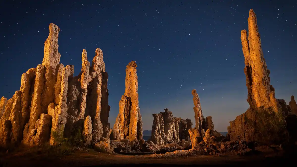 At night, Mono Lake's soda waters gleam, revealing eerie tufa towers that resemble termite mounds or alien skyscrapers. This…