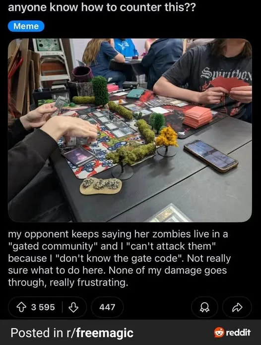 A photo of people playing a tabletop game with miniature figures and cards on a table. One player's hands are visible near…