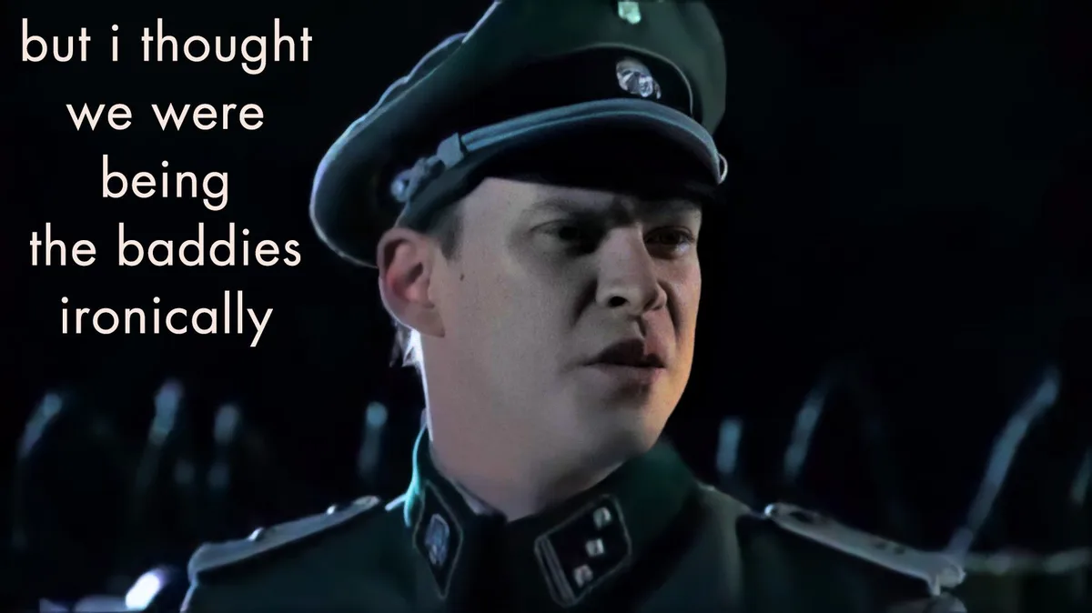 A close-up of a young man in a dark green military uniform and cap, looking confused or betrayed. White text on the left…