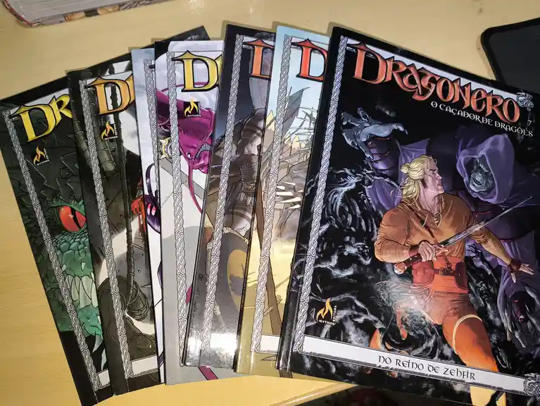 A fanned-out stack of 'Dragonero: O Caçador de Dragões' comic books by Mythos Editora, showing various cover art including a…