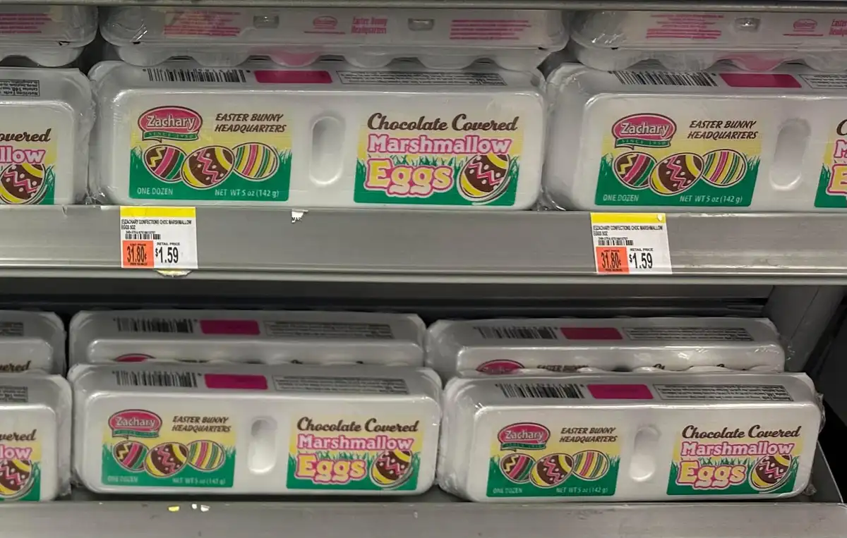 A grocery store shelf displays multiple packages of Zachary brand 'Chocolate Covered Marshmallow Eggs' from 'Easter Bunny…
