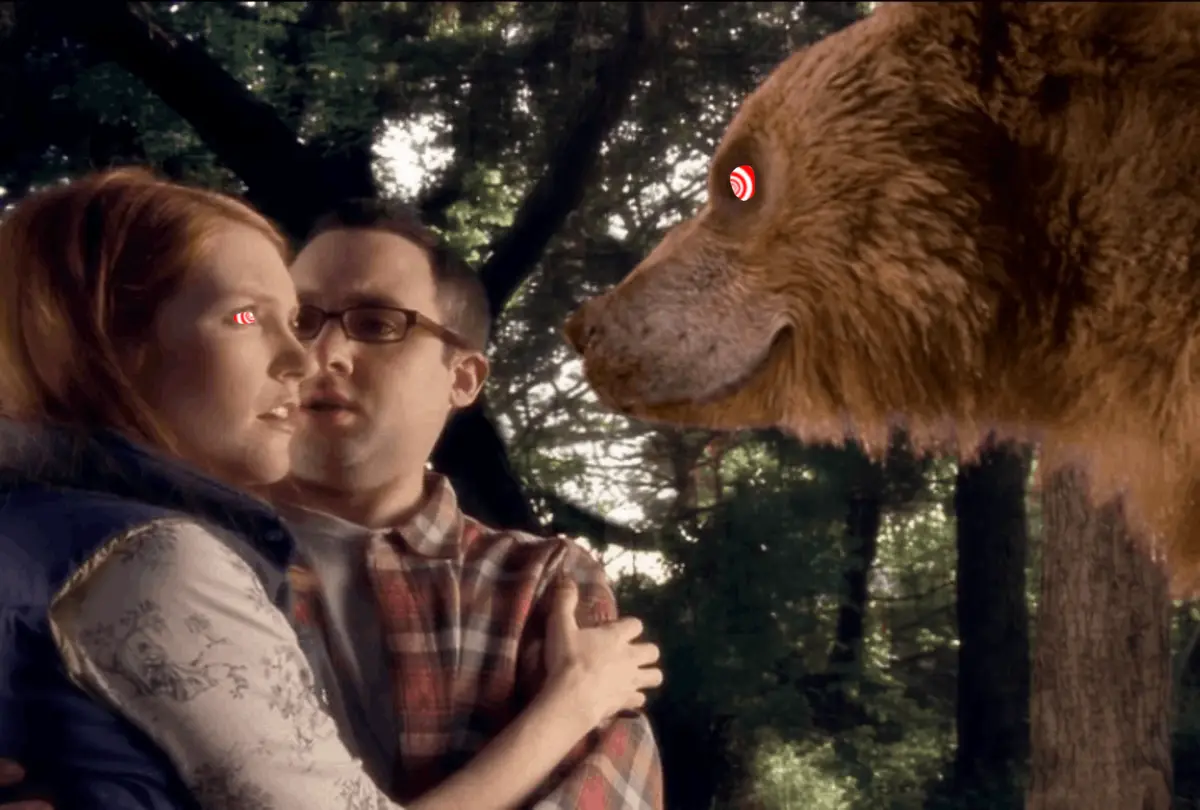 The image shows a repeating scene of a man and woman embracing in a forest, with a large bear looming behind them. Both the…