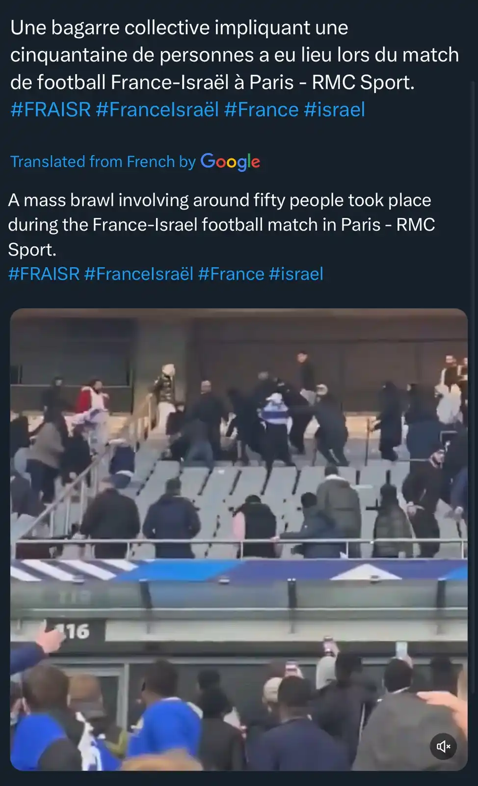 A chaotic scene in a stadium shows dozens of people engaged in a physical brawl on the upper tier seating area, with some…