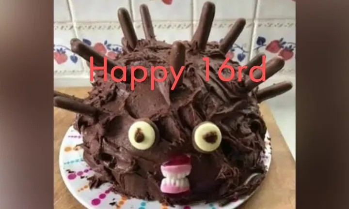 A chocolate cake decorated to look like a monstrous creature with chocolate stick spikes, two large round eyes made from…