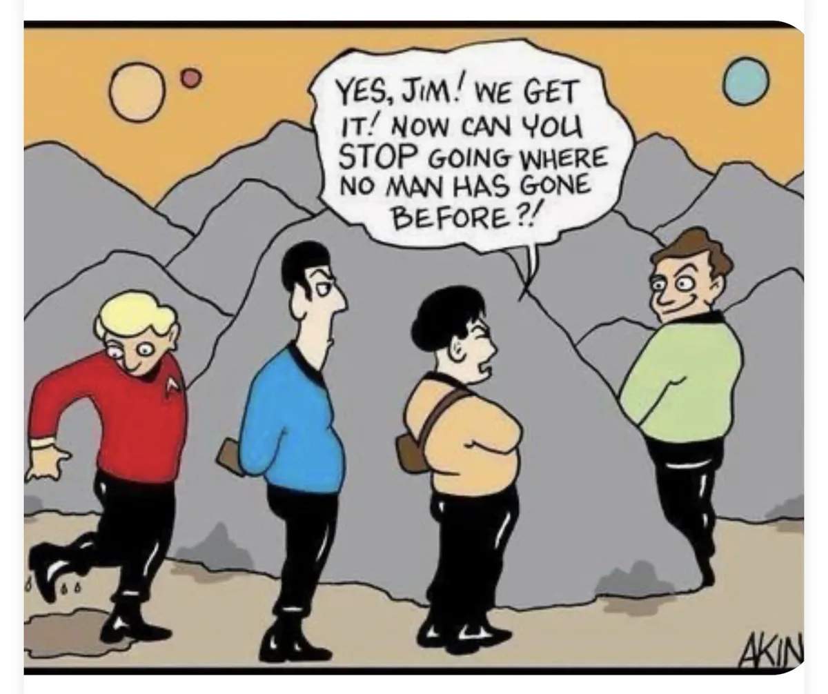 A cartoon depicts four men in Star Trek-style uniforms standing in a rocky, alien landscape with multiple suns. One man in a…