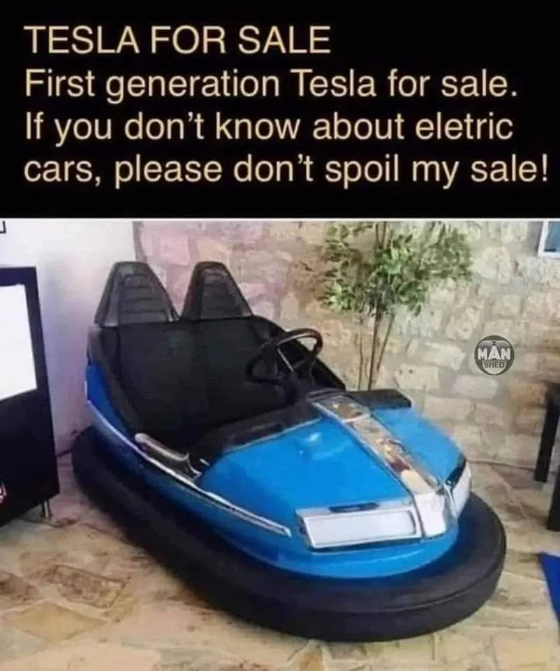 A blue bumper car with black seats and a steering wheel is shown indoors on a tiled floor, with a stone wall and plant in…