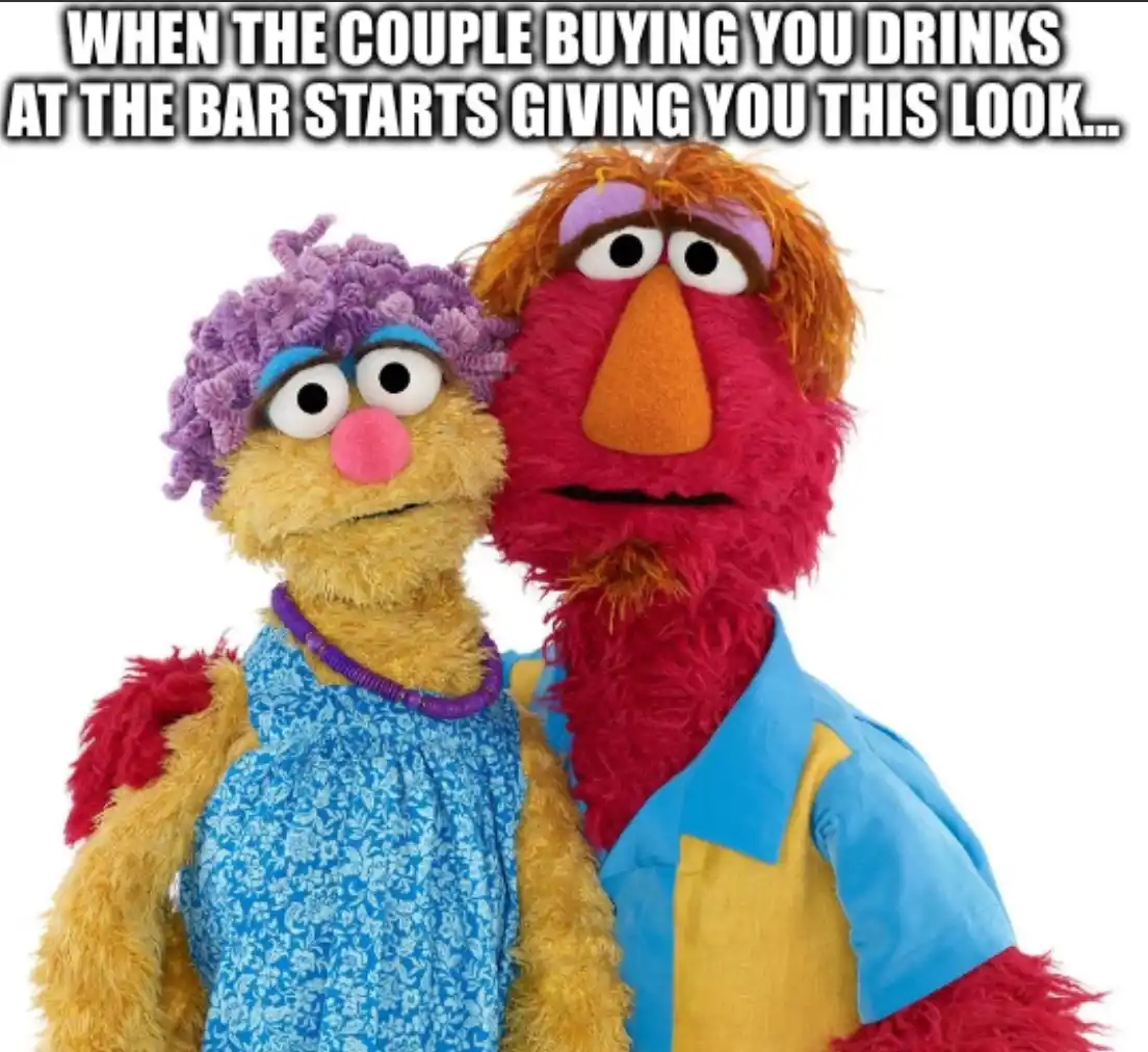 Two Muppet characters, a female with purple curly hair and a blue dress, and a male with red fur and a blue-and-yellow…
