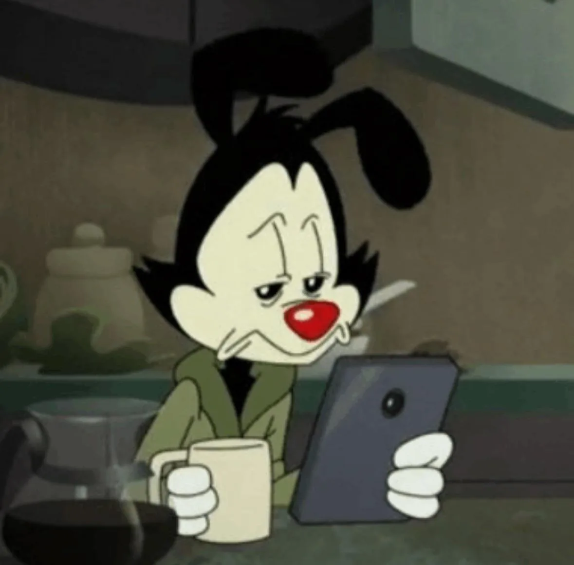 a cartoon character with black hair and a red nose, wearing a green jacket, sits at a kitchen counter holding a mug in one…