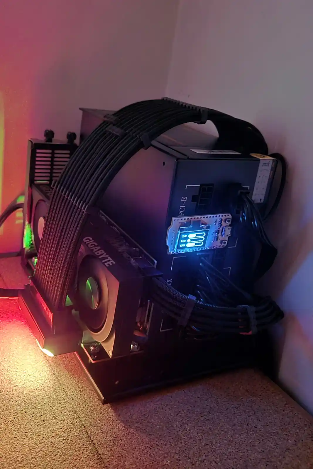 A computer motherboard with a Gigabyte graphics card and various cables is shown in a corner, illuminated by red and blue…