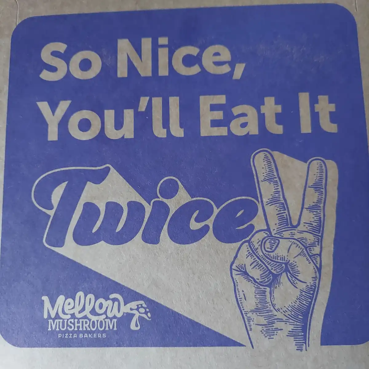 A blue Mellow Mushroom pizza baker coaster features the slogan 'So Nice, You'll Eat It Twice' in large beige text, with a…