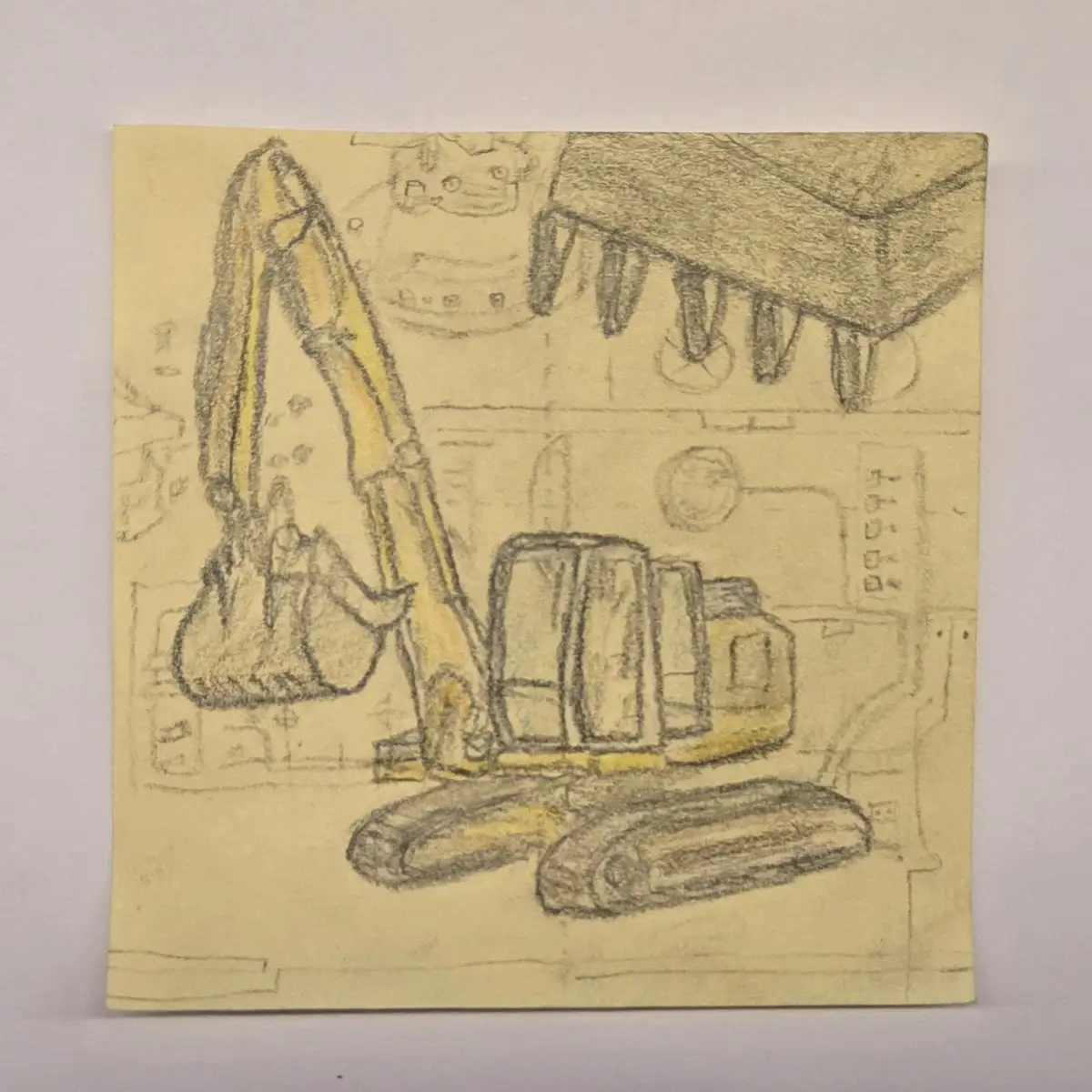 A hand-drawn sketch on yellow paper depicts a yellow excavator with a bucket and tracks, alongside other faint sketches…
