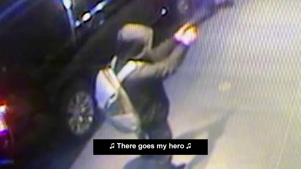 A grainy, low-resolution surveillance-style image shows a person in a dark hoodie and light-colored backpack standing beside…
