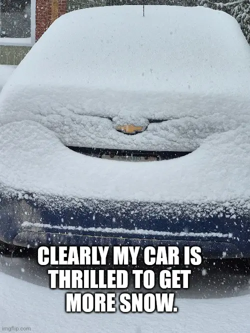 A blue car is completely covered in snow, with only the Chevrolet emblem and license plate visible. The overlaid text reads…